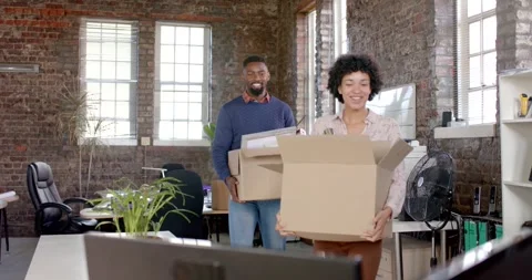 Happy diverse colleagues holding boxes with documents and office items in slow Stock Footage 335129923