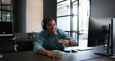 Happy diverse colleagues using computer with headset, discussing work and Stock Footage 317290390