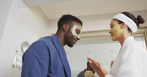Happy diverse couple with doing make ups and looking at each other in bathroom Stock Footage 344380488