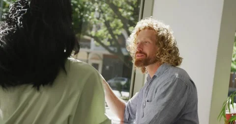 Happy diverse couple drinking coffee and talking in cafe Vídeo Stock 342110976