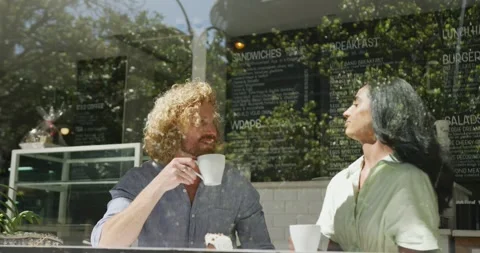 Happy diverse couple drinking coffee and talking in cafe Vídeo Stock 342715602