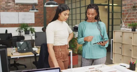 Happy diverse female architects looking at architectural models and using tablet Stock Footage 336844116