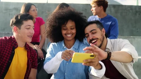 Happy diverse friends using smartphone together at urban city Stock Footage 315337067