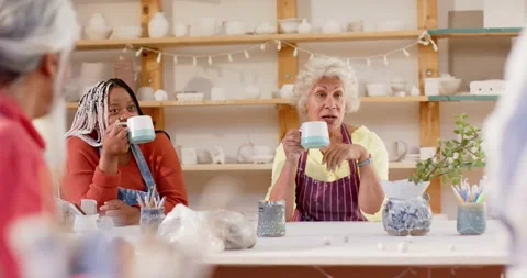 Happy diverse group of potters having break and discussing in pottery studio, Stock Footage 344103697