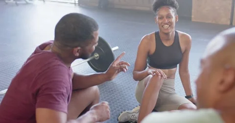 Happy diverse group sitting and talking after training in fitness class at gym, Stock Footage 337932391