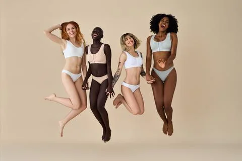 Happy Diverse Young Women Group Wearing Underwear Hugging on Beige