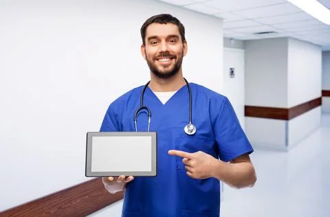 Happy doctor or male nurse showing tablet computer Stock Photos
