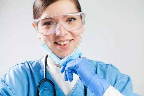 Happy doctor pulling down protective medical face mask Foto stock