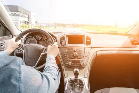 Happy driver inside car at sunset. Young man have fun ride trip travel on roa Stock Photos