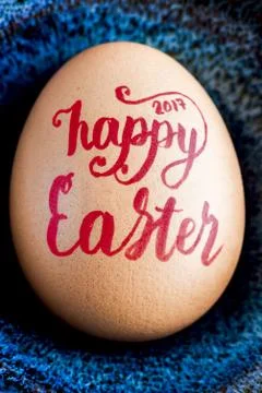 Happy Easter 2017 Handwritten in red lettering on egg closeup. Stock Photos