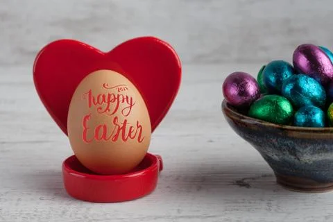 Happy Easter 2017 lettering on egg with red heart shaped holder and chocola.. Stock Photos