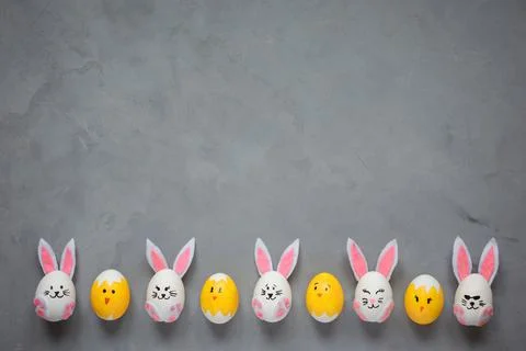 Happy Easter background, bunny and chicken painted eggs on the gray background. Stock Photos