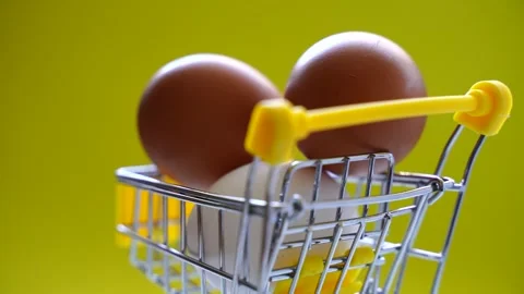 Happy Easter background. Easter eggs in the shopping cart on bright yellow paper Vídeo Stock 262186479