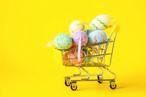 Happy Easter background.Easter eggs colorful in the shopping cart on bright y Stock Photos