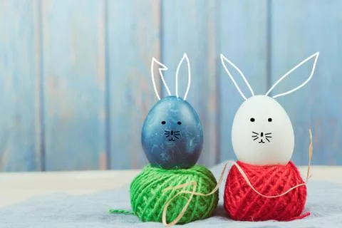 Happy easter, blue and white organic eggs standing on the colorful rope, east Stock Photos