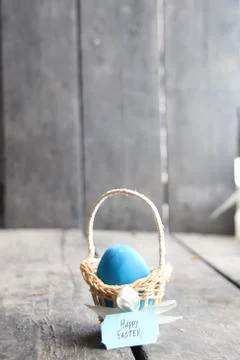 Happy easter. Blue egg on rustic table and a basket with a tag Stock Photos