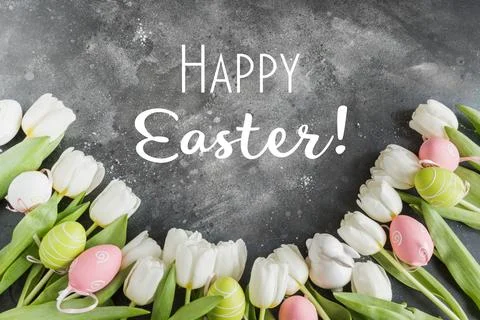 Happy Easter. Border of white tulips, eggs on vintage gray. Top view. Foto stock