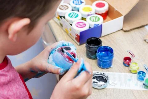 Happy easter! A boy painting Easter eggs at home. A child preparing the easte Stock Photos