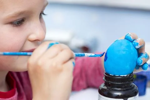 Happy easter! A boy painting Easter eggs at home. A child preparing the easte Stock Photos