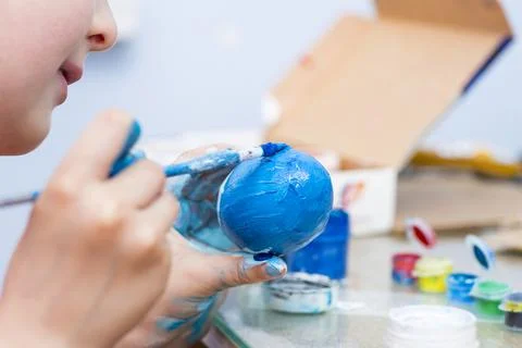 Happy easter! A boy painting Easter eggs at home. A child preparing the easte Stock Photos