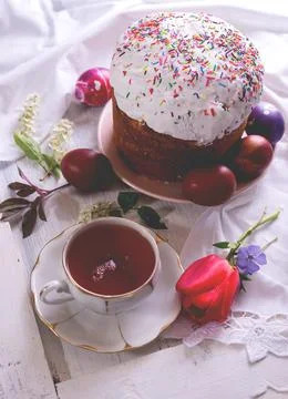 Happy Easter breakfast still life with White porcelain cup of tea, colored eggs Stock Photos