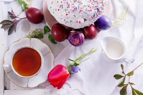 Happy Easter breakfast still life with White porcelain cup of tea, colored eggs Stock Photos