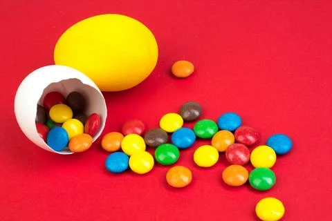 Happy Easter. Broken Easter egg with multi-colored candy decorations. on re.. Stock Photos