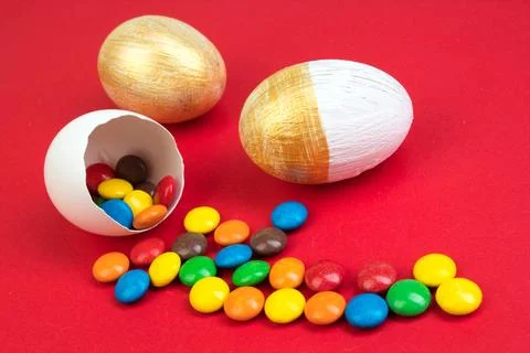 Happy Easter. Broken Easter egg with multi-colored candy decorations. on re.. Stock Photos