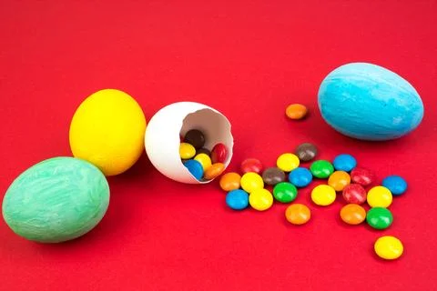 Happy Easter. Broken Easter egg with multi-colored candy decorations. on re.. Stock Photos