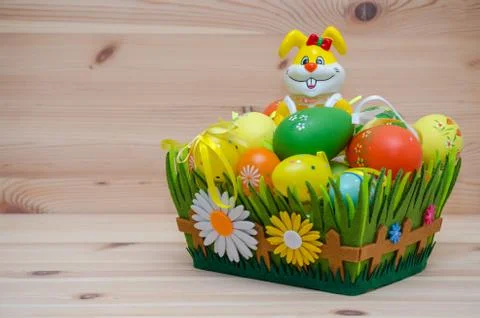 Happy easter bunny with eggs in a basket on the wooden background Stock Photos