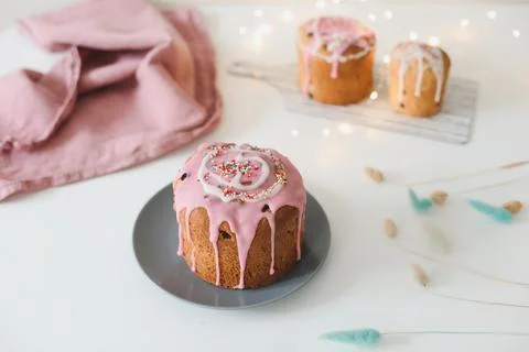 Happy Easter cake with sprinkles on glaze. Cake on light rustic board. Homemade Stock Photos