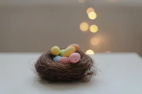 Happy Easter card. Colorful easter eggs in nest on white festive background with Stock Photos