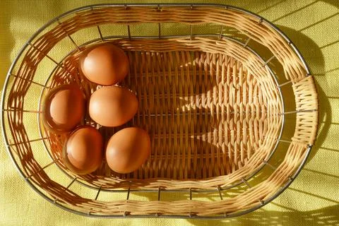 Happy Easter. Chicken eggs in a wicker basket on a yellow background Stock-Fotos