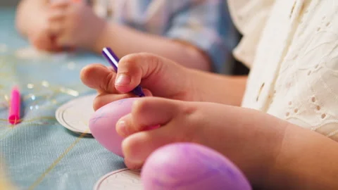 Happy Easter. Children decorate Easter eggs at the table at home, close-up. Video stock 258464597