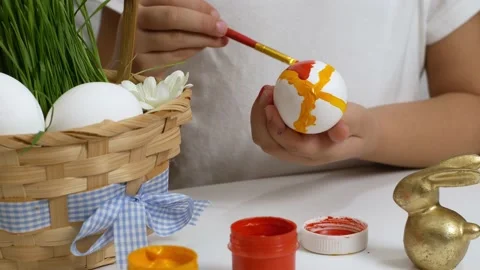 Happy Easter. Children drawing on painted eggs at the table, at home. Preparing Stock Footage 168379769