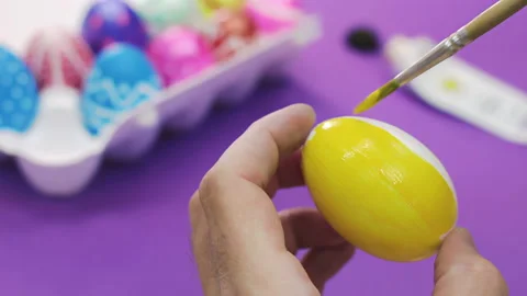 Happy Easter Close Up. White man painting a yellow Easter egg with a brush Stock Footage 172146981