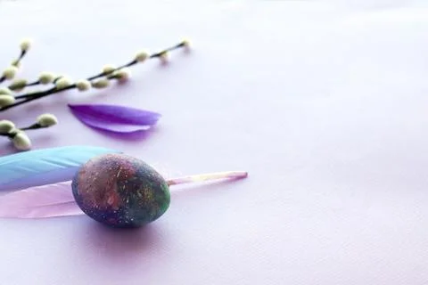 Happy Easter, colored egg, bright feathers on a purple background Stock Photos