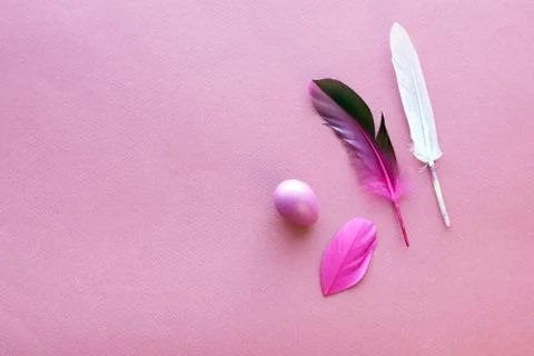 Happy Easter, colored egg, bright feathers on a purple background Stock Photos