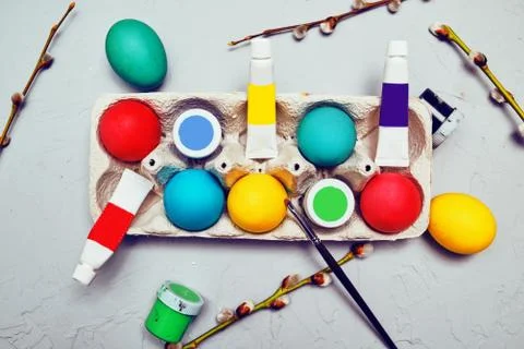 Happy easter. Colored eggs on gray concrete. Flowering, fur-seal willow, on a Stock Photos