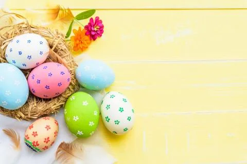Happy easter! Colorful of Easter eggs in nest with red ribbon, Feather and pa Stock Photos