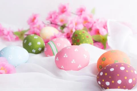 Happy easter! Colorful of Easter eggs in nest with flower and Feather on whit Stock Photos