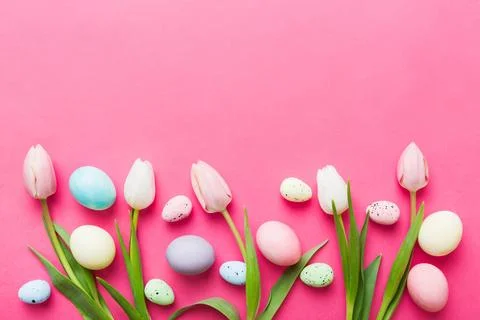Happy Easter composition. Easter eggs on colored table with yellow Tulips. .. Stock Photos