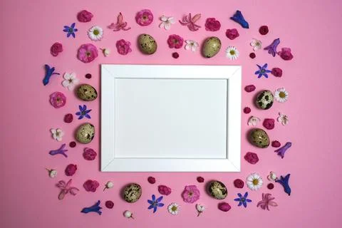 Happy Easter composition. Easter eggs, flowers, photo frame Stock Photos