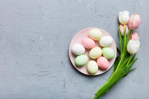 Happy Easter composition. Easter eggs in basket on colored table with yellow  스톡 사진