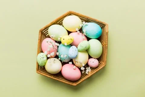 Happy Easter composition. Easter eggs in basket on colored table with gypsoph Foto stock