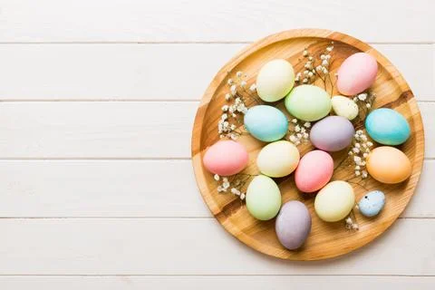 Happy Easter composition. Easter eggs in basket on colored table with gypso.. Stock Photos