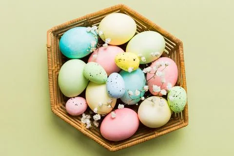 Happy Easter composition. Easter eggs in basket on colored table with gypso.. 스톡 사진