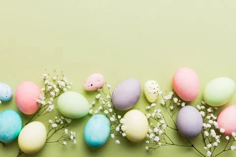 Happy Easter composition. Easter eggs on colored table with gypsophila. Nat.. Stock Photos