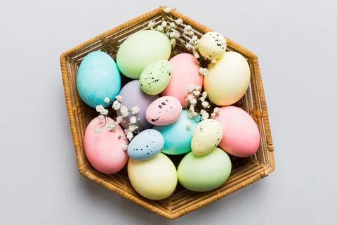 Happy Easter composition. Easter eggs in basket on colored table with gypso.. Foto stock