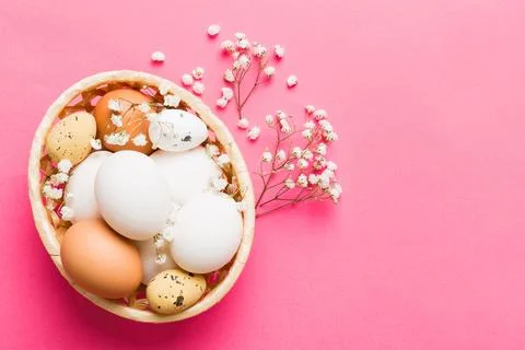 Happy Easter composition. Easter eggs in basket on colored table with gypso.. 库存照片